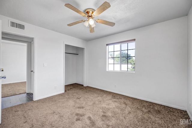 unfurnished bedroom with a closet, light colored carpet, and ceiling fan