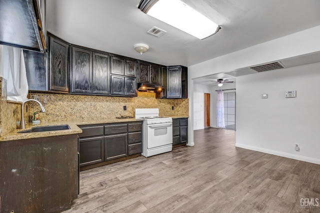 kitchen featuring ceiling fan, sink, white range, backsplash, and light hardwood / wood-style floors