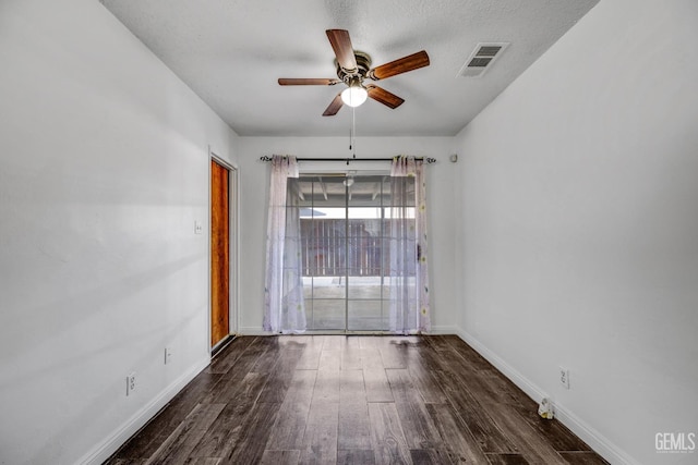 empty room featuring ceiling fan, dark hardwood / wood-style flooring, and a textured ceiling