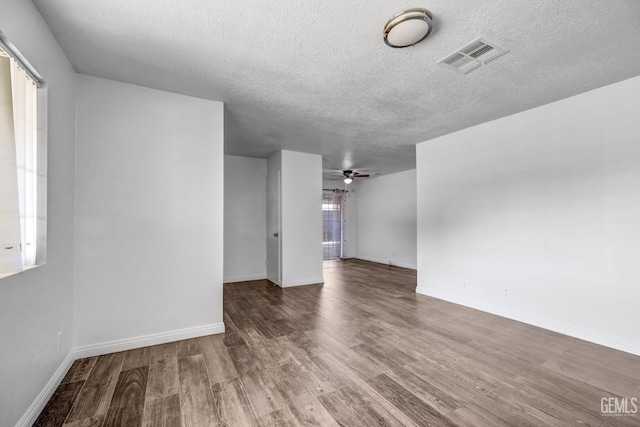 empty room with hardwood / wood-style flooring, ceiling fan, and a textured ceiling