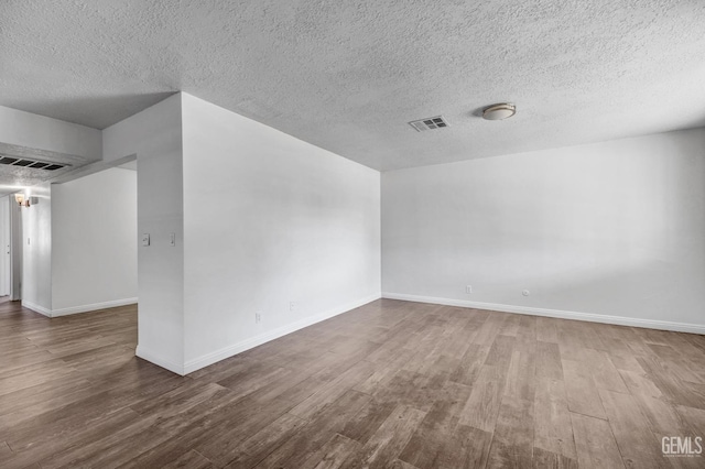 spare room featuring a textured ceiling and hardwood / wood-style flooring