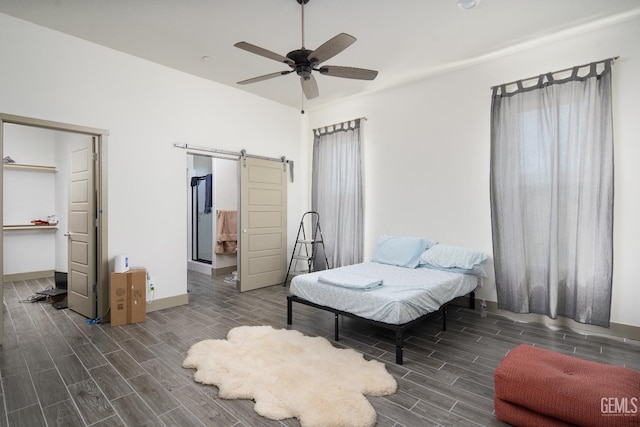 6622 Sycamore Wood Ln, Bakersfield, CA 93313 - bedroom with a barn door, wood finish floors, a spacious closet, ceiling fan, and a closet