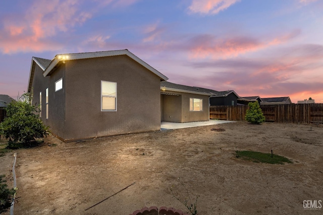 6622 Sycamore Wood Ln, Bakersfield, CA 93313 - back of house at dusk featuring stucco siding and a patio