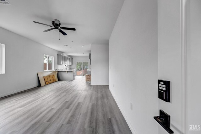1627 Tejon St, Bakersfield, CA 93305 - unfurnished living room featuring ceiling fan, wood finished floors, baseboards, and a sink