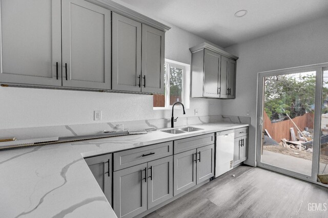 1627 Tejon St, Bakersfield, CA 93305 - kitchen with a sink, gray cabinetry, dishwasher, light wood-style flooring, and light stone counters
