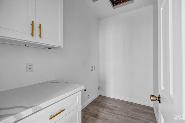 1627 Tejon St, Bakersfield, CA 93305 - laundry room featuring cabinet space, wood finished floors, and baseboards