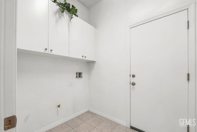 washroom with cabinet space, light tile patterned flooring, washer hookup, and baseboards