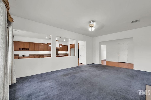 unfurnished living room featuring carpet flooring and visible vents