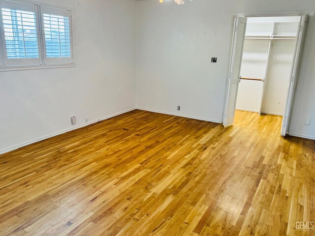 unfurnished bedroom featuring light hardwood / wood-style flooring and a closet