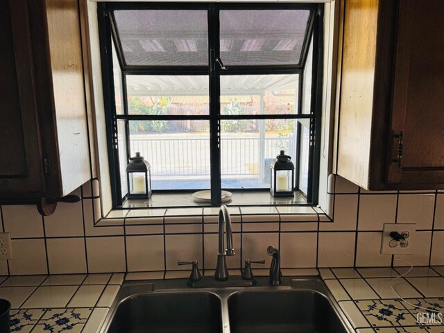 interior details with backsplash, sink, and dark brown cabinets