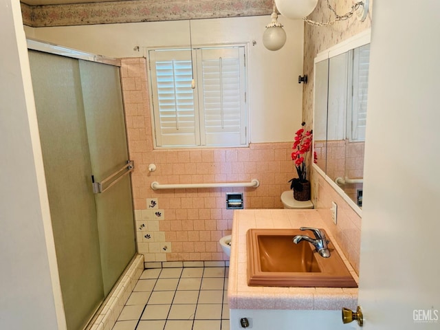 bathroom featuring a shower with door, tile patterned floors, tile walls, and sink