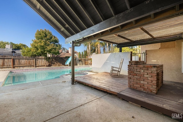 view of pool with a deck, a patio, a pool with connected hot tub, and a fenced backyard