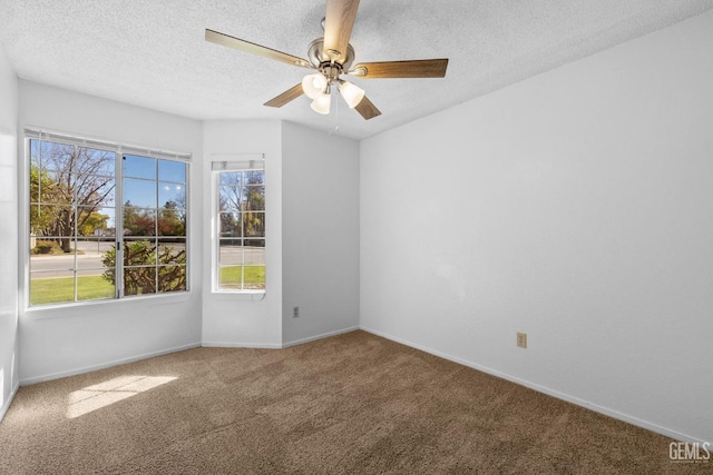 carpeted empty room with ceiling fan, baseboards, and a textured ceiling