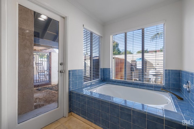 bathroom with tile patterned floors, ornamental molding, and a bath