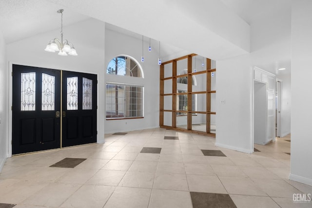 foyer with baseboards, a notable chandelier, high vaulted ceiling, and tile patterned flooring