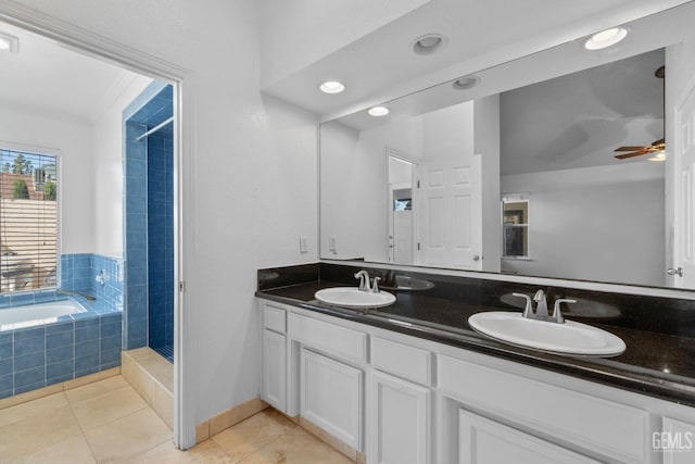 bathroom with a sink, tiled tub, double vanity, and tile patterned flooring