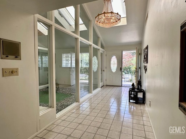 interior space featuring a chandelier, light tile patterned floors, and vaulted ceiling