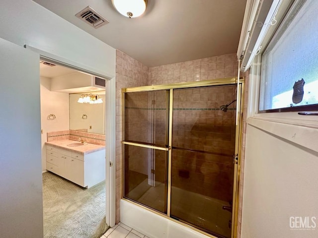 bathroom featuring vanity, tile patterned floors, and enclosed tub / shower combo