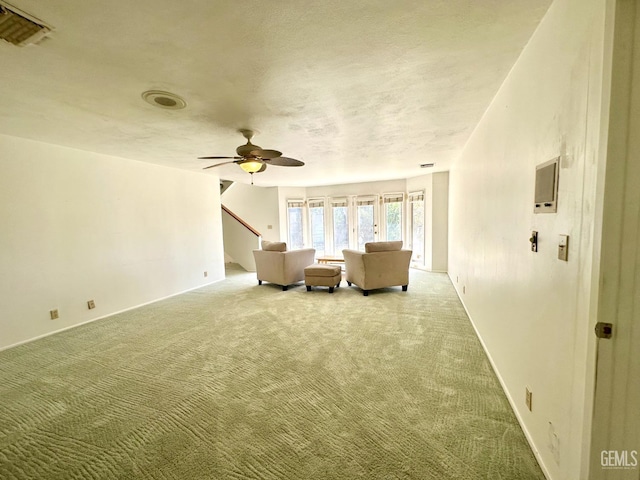 unfurnished room featuring a textured ceiling, carpet floors, and ceiling fan