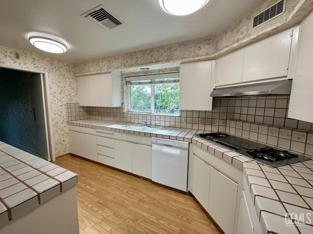 kitchen with white cabinets, tile counters, and white dishwasher