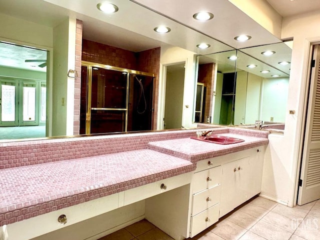 bathroom with tile patterned flooring, vanity, and a shower with shower door