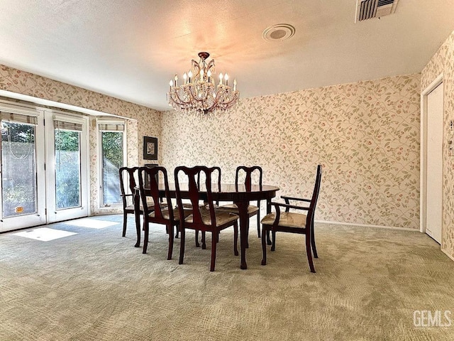 carpeted dining room with an inviting chandelier