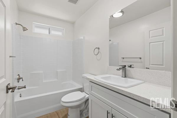 664 Fresno Ave, Shafter, CA 93263 - bathroom featuring vanity, shower / bathtub combination, and wood finished floors