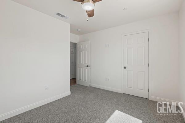 664 Fresno Ave, Shafter, CA 93263 - unfurnished bedroom with carpet and ceiling fan