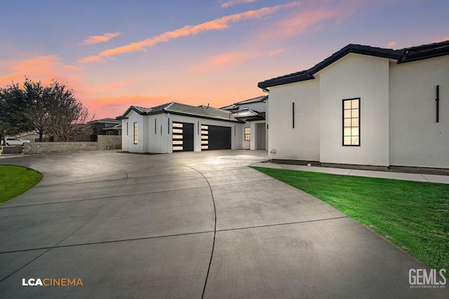 view of front of home with a garage and a yard