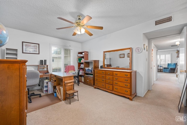 carpeted office featuring ceiling fan and a textured ceiling