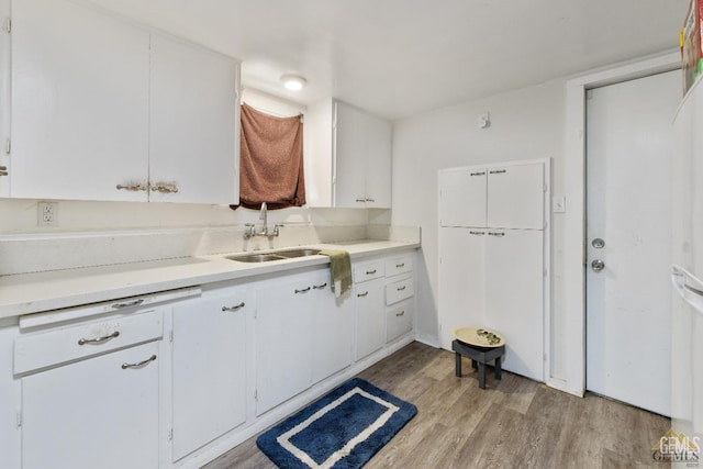 210 B B, Taft, CA 93268 - kitchen with a sink, light wood-style flooring, white cabinets, and light countertops