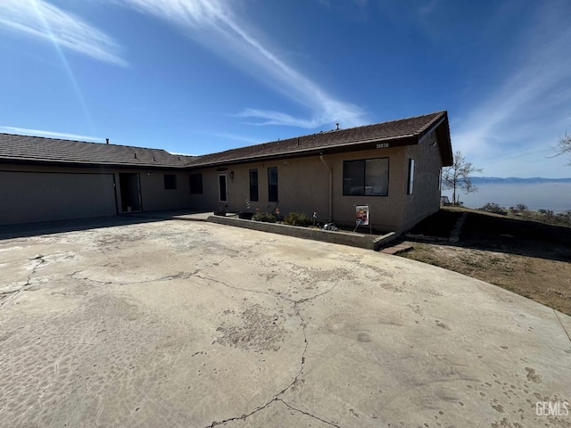 view of front of house featuring stucco siding, concrete driveway, and an attached garage