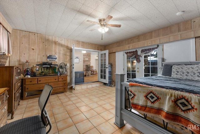 tiled bedroom with access to outside, wood walls, french doors, and ceiling fan