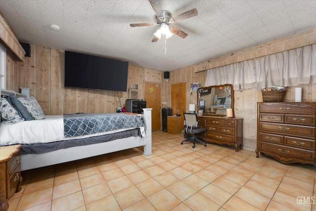 bedroom featuring wooden walls, ceiling fan, and a textured ceiling