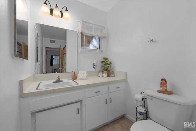 bathroom featuring tile patterned flooring, vanity, and toilet