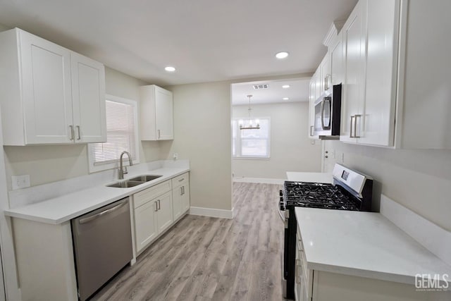 2408 Charleston Dr, Bakersfield, CA 93308 - kitchen featuring stainless steel appliances, light wood-style flooring, white cabinets, and recessed lighting