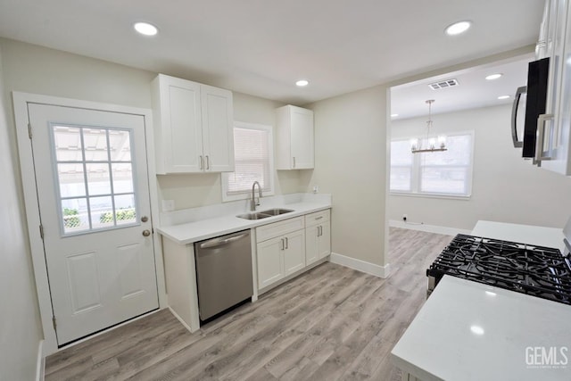 2408 Charleston Dr, Bakersfield, CA 93308 - kitchen with stainless steel dishwasher, white cabinetry, light wood finished floors, plenty of natural light, and recessed lighting