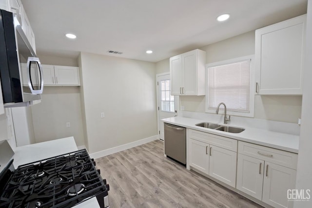 2408 Charleston Dr, Bakersfield, CA 93308 - kitchen with stainless steel appliances, white cabinetry, light wood-style floors, light countertops, and recessed lighting