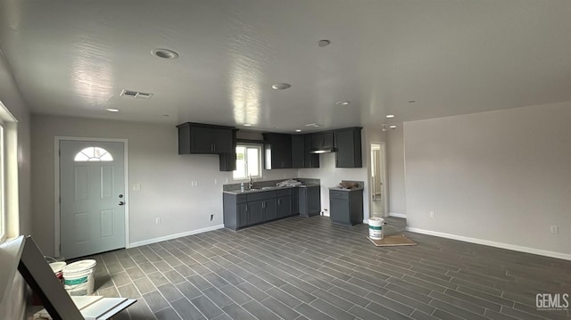 kitchen with dark wood finished floors, a sink, baseboards, and visible vents