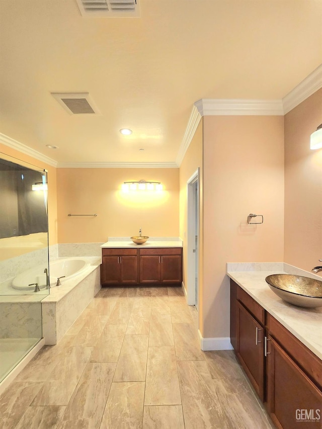 bathroom featuring crown molding, vanity, and tiled bath