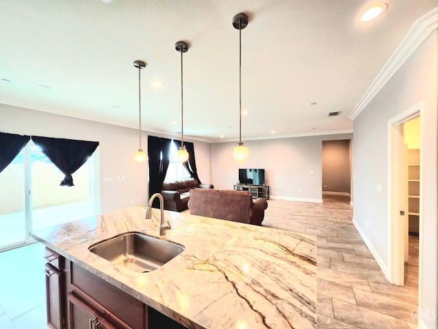 kitchen featuring sink, decorative light fixtures, ornamental molding, and light stone countertops