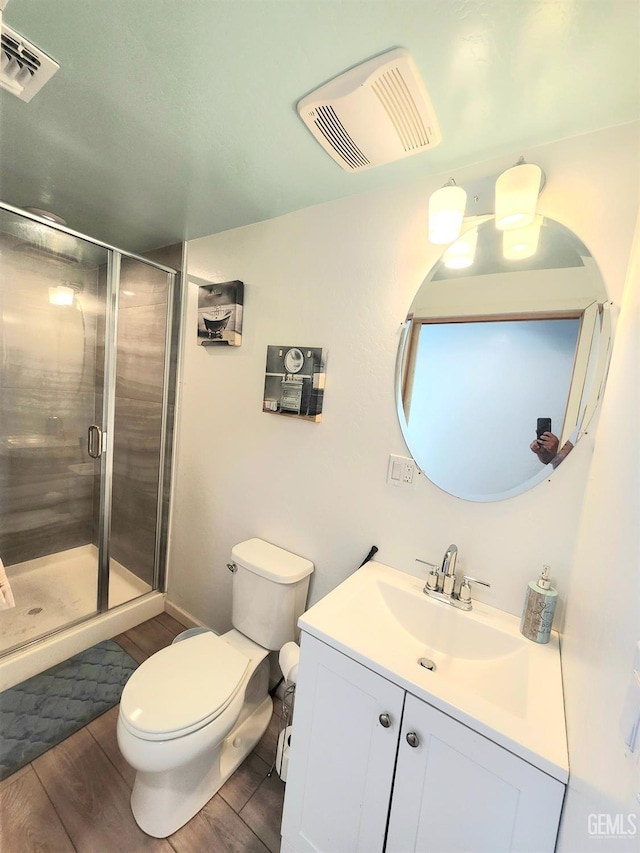 bathroom with vanity, an enclosed shower, hardwood / wood-style flooring, and toilet