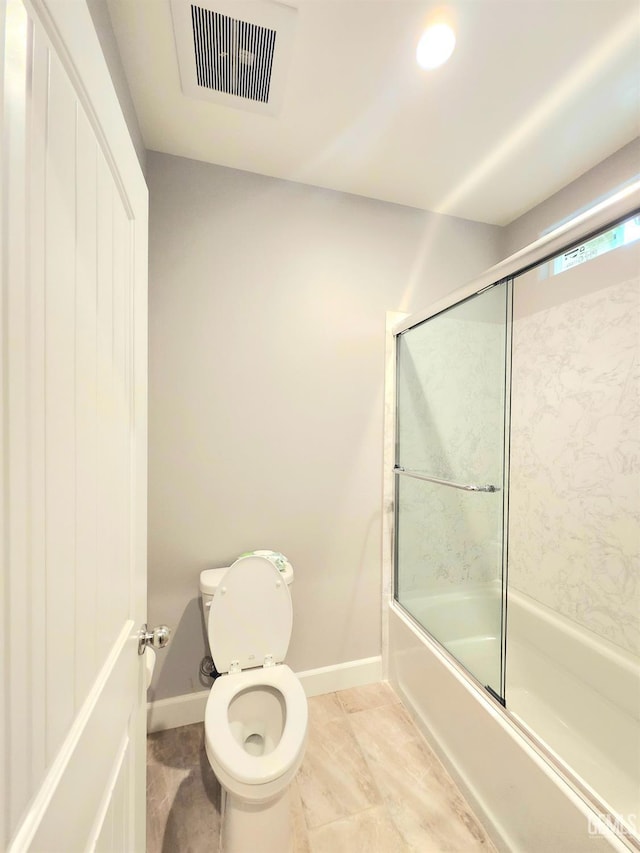 bathroom featuring enclosed tub / shower combo and toilet