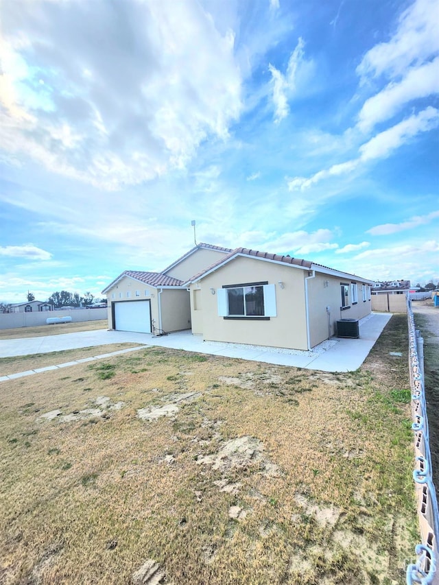 ranch-style house with a garage, a patio area, and a front yard