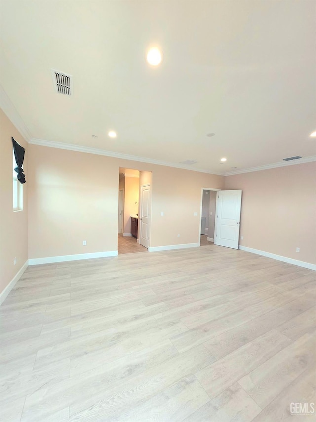 spare room featuring crown molding and light wood-type flooring