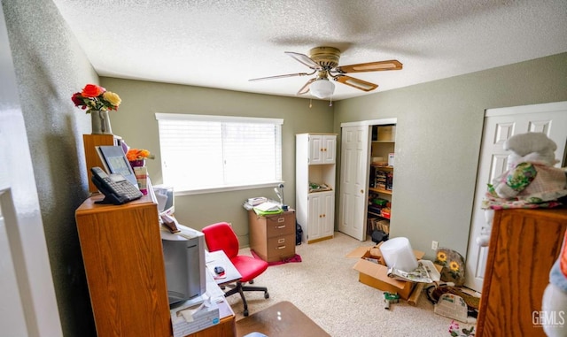 carpeted bedroom with ceiling fan and a textured ceiling