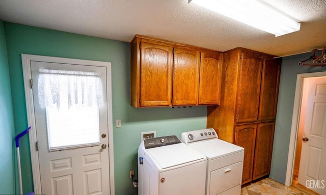 laundry area with cabinets, plenty of natural light, a textured ceiling, and washing machine and clothes dryer