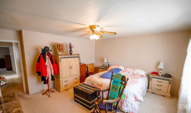 carpeted bedroom featuring a textured ceiling and ceiling fan