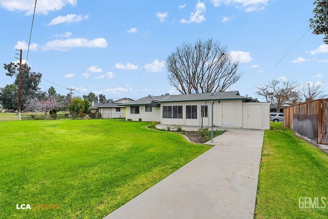 single story home featuring a front yard, concrete driveway, and fence