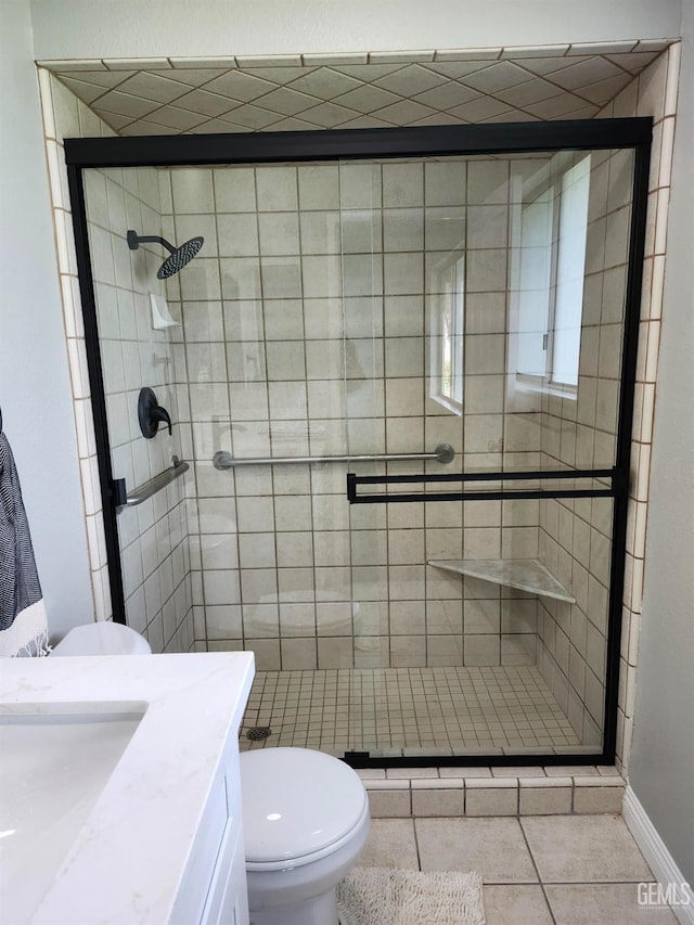 full bath with tile patterned flooring, a shower stall, toilet, and vanity